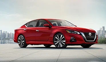 2023 Nissan Altima in red with city in background illustrating last year's 2022 model in Lupient Nissan in Brooklyn Park MN