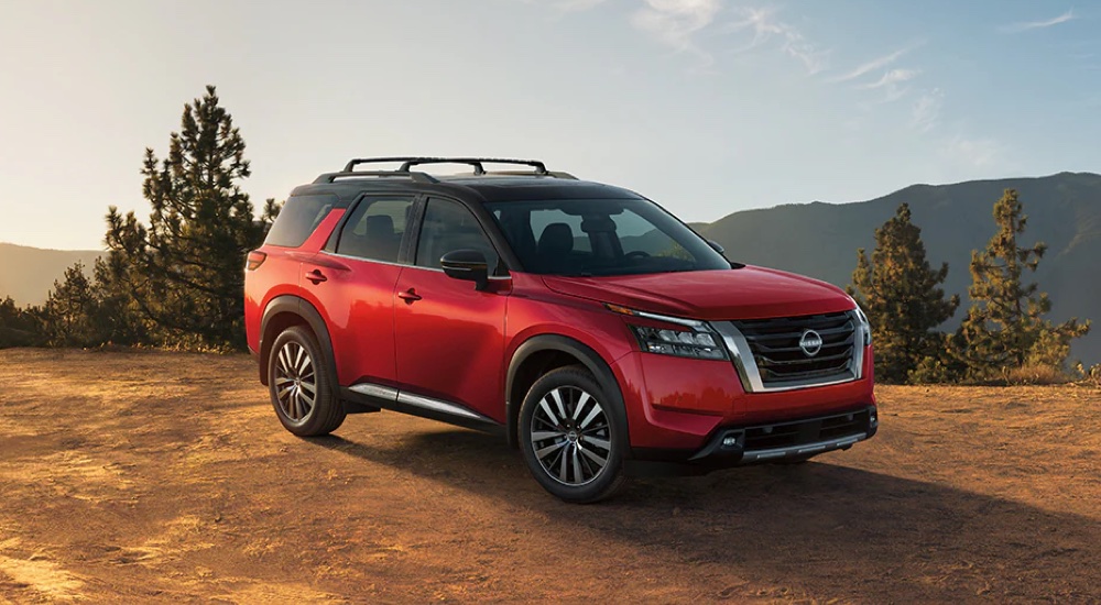 A red and black 2025 Nissan Pathfinder Platinum parked on a hilltop.