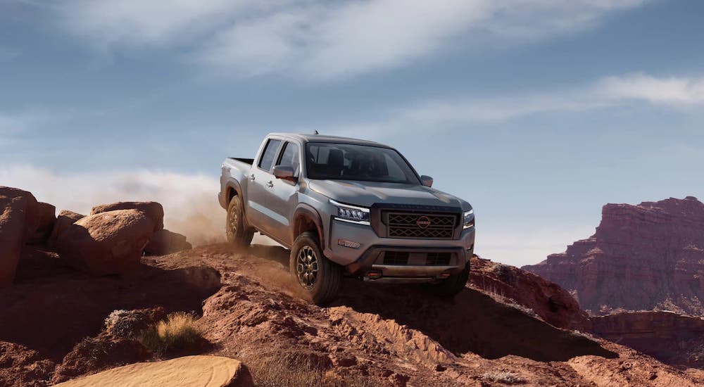 Grey 2025 Nissan Frontier driving down a cliff.