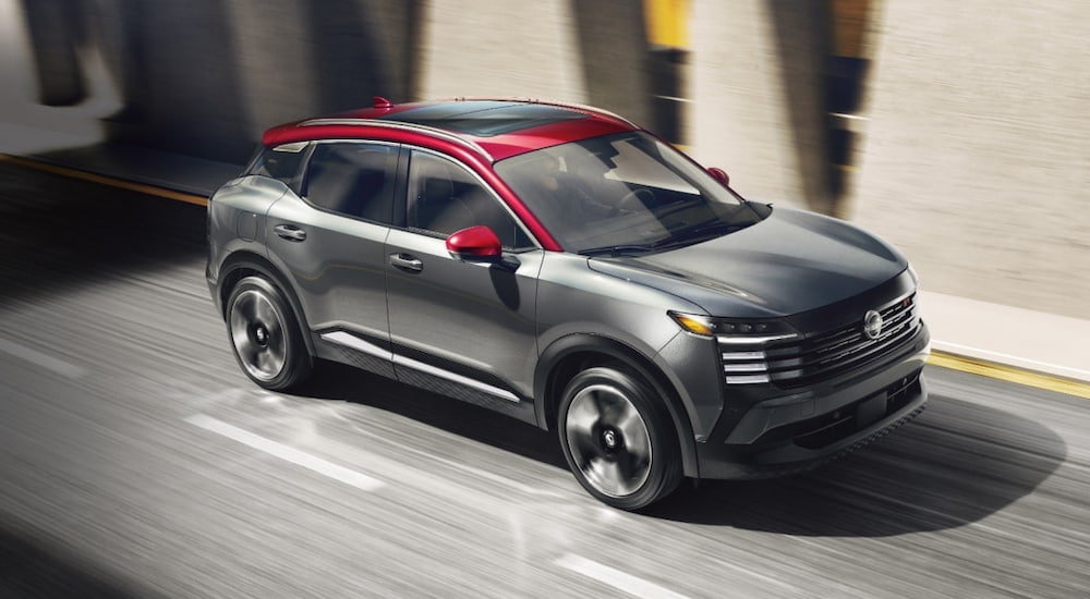 Black 2025 Nissan Kicks SR for sale driving down a road.