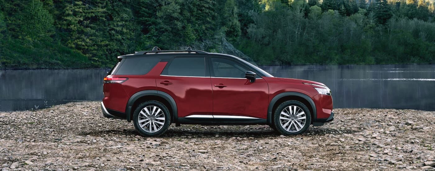 A red 2023 Nissan Pathfinder is shown from the side.
