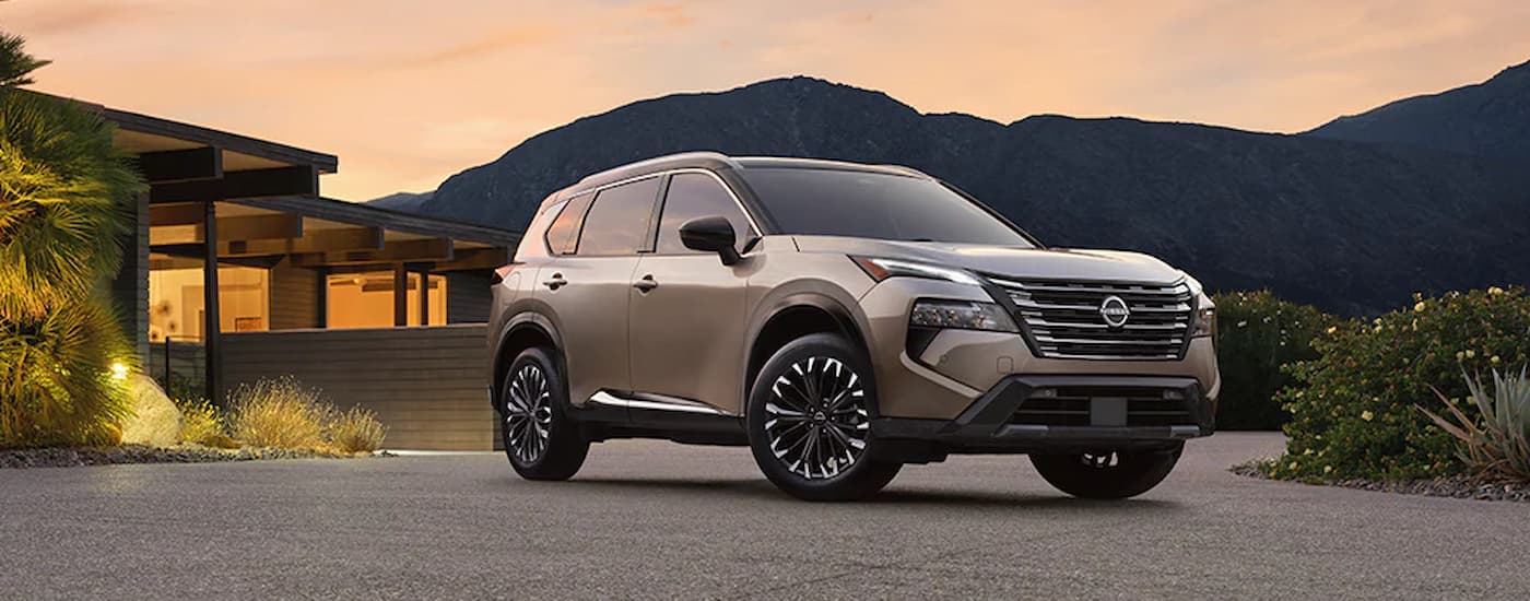 A tan 2025 Nissan Rogue parked off-road after visiting a Nissan dealer near Fridley